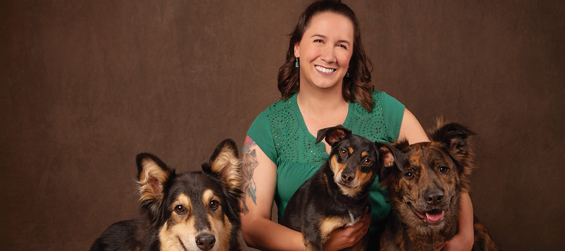 Emily sitting with her three dogs for a professional photo shoot