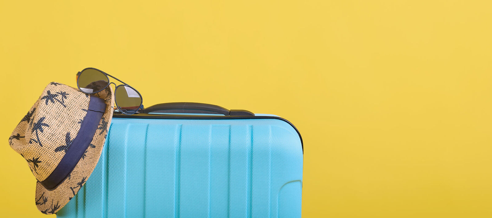 Suitcase with beach hat and sunglasses