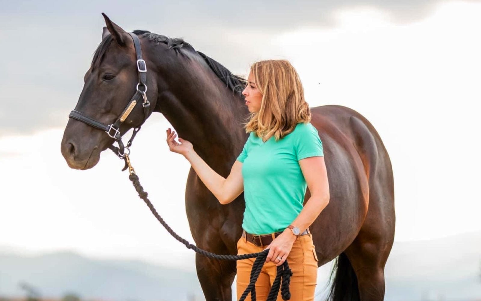 Dr. Chelsea Luedke, equine veterinarian and co-founder of VetCS, standing beside a horse outdoors