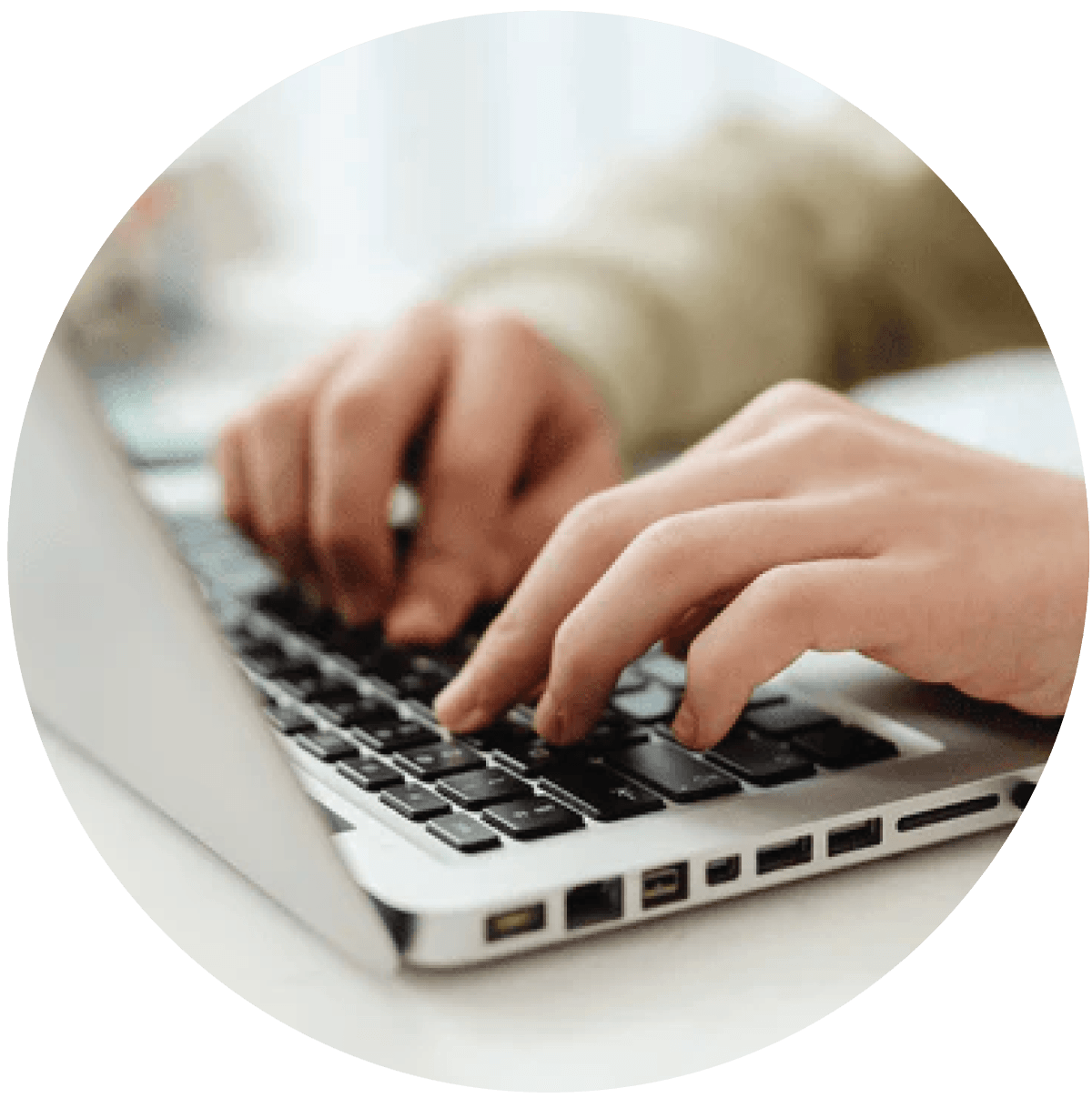 Close-up of hands typing on a laptop keyboard