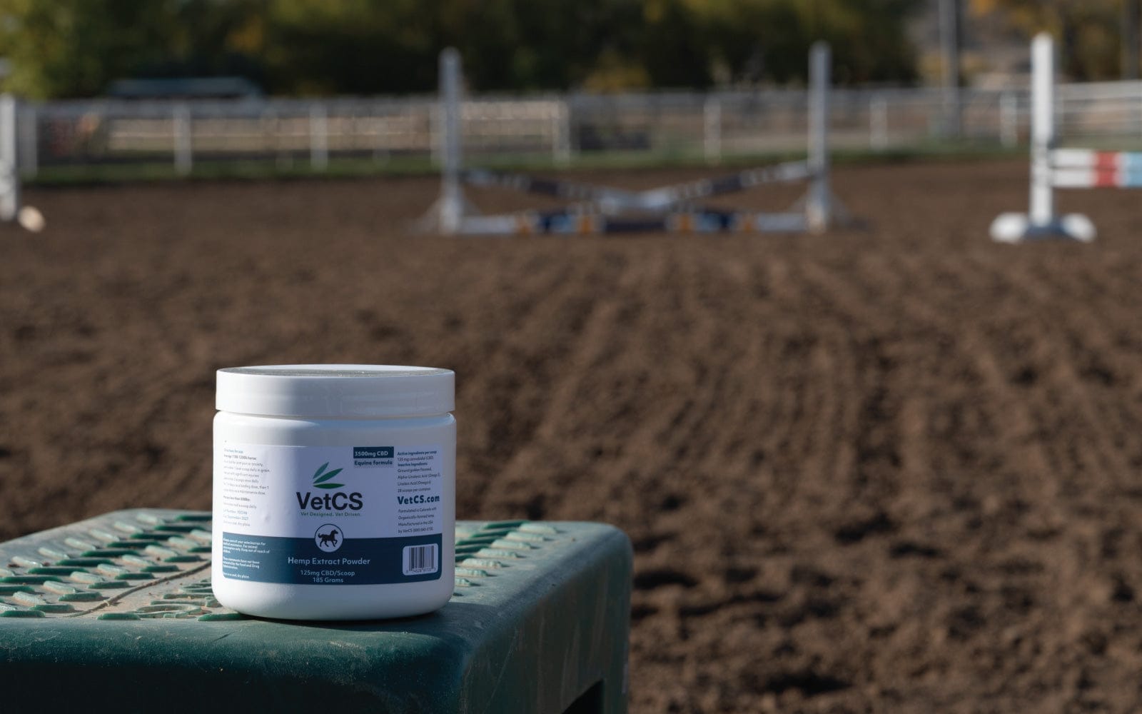 White container labeled 'VetCS' on a green surface with a blurred outdoor background