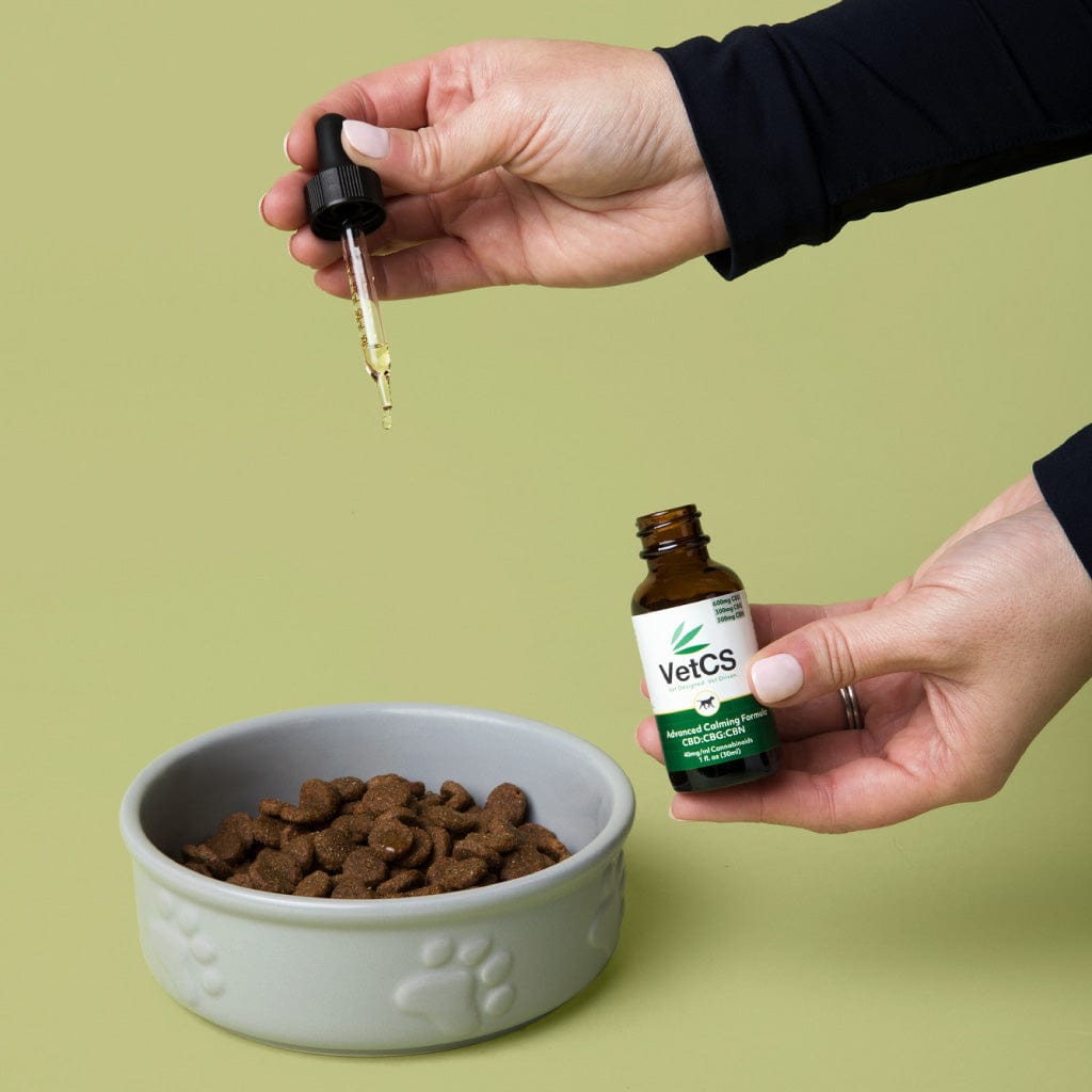 VetCS CBD oil for dogs being added to kibble, showing easy daily CBD use for canine health and wellness.
