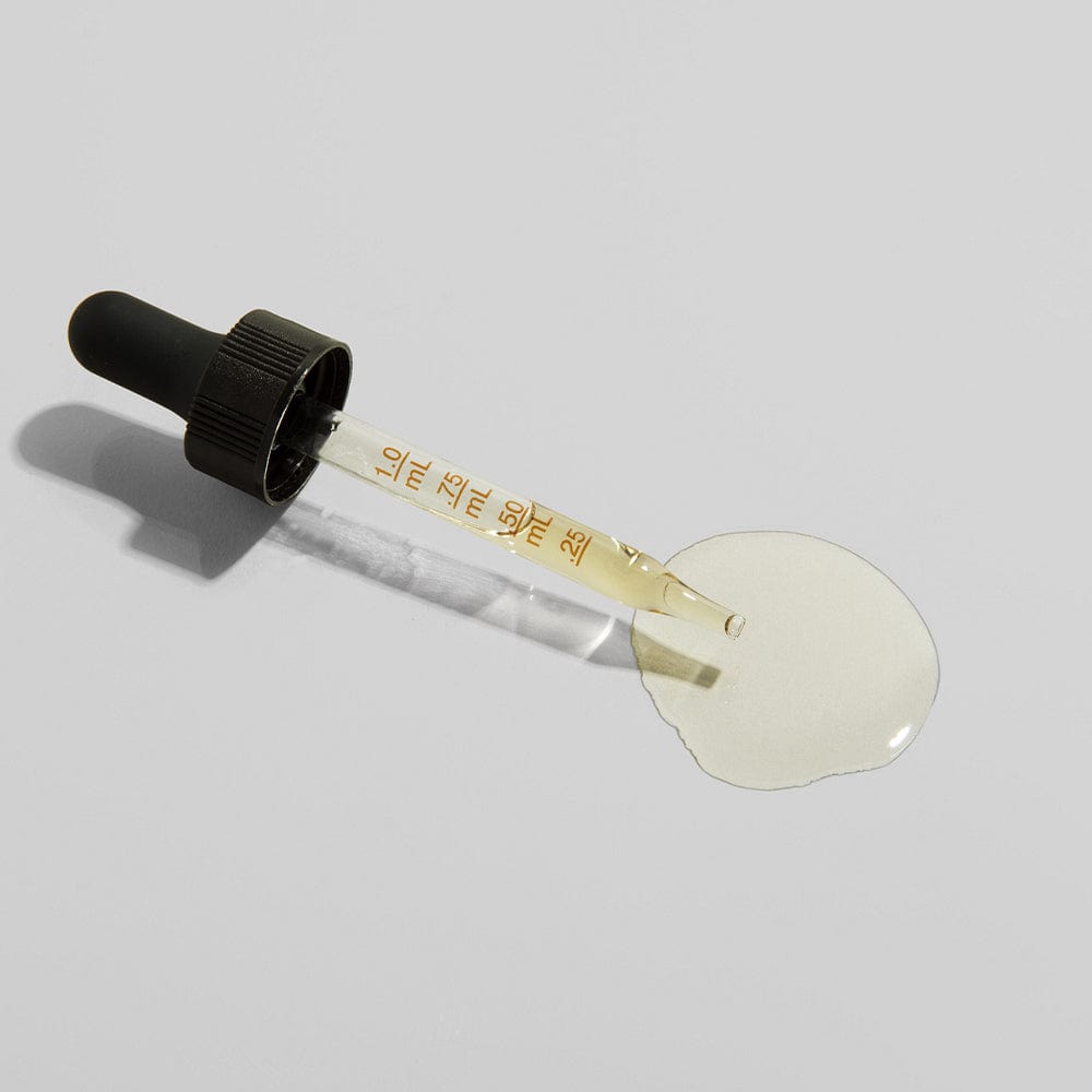 VetCS tincture dropper full of CBD oil on grey background.