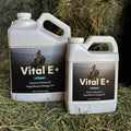 Two bottles of Vital E+ on a hay background